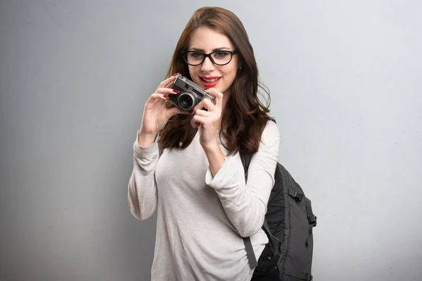 Estudiante sosteniendo una cámara sobre fondo texturizado —  Fotos de Stock