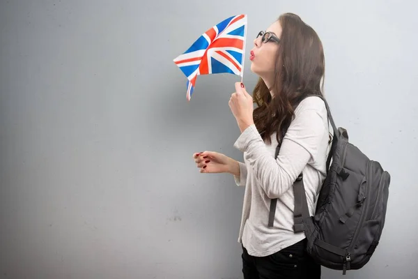 在带纹理的背景上手持英国国旗的学生女人 — 图库照片