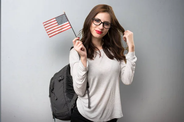 Estudiante sosteniendo una bandera americana sobre fondo texturizado —  Fotos de Stock