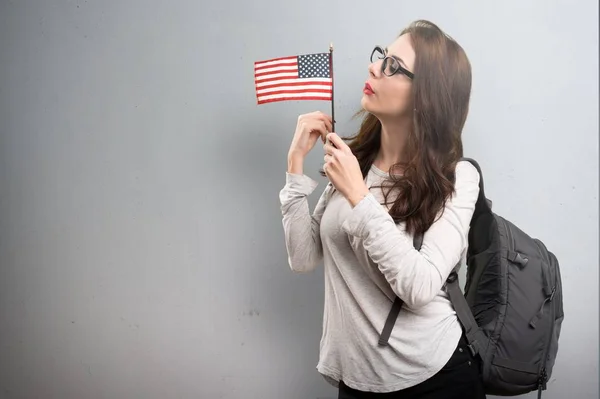 Estudiante sosteniendo una bandera americana sobre fondo texturizado —  Fotos de Stock