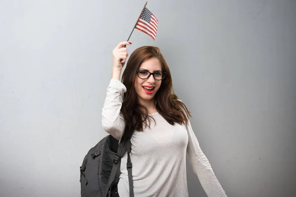 Estudiante sosteniendo una bandera americana sobre fondo texturizado —  Fotos de Stock