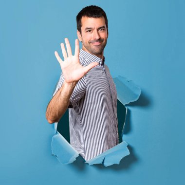 Yakışıklı adam beş kağıt delikten sayma