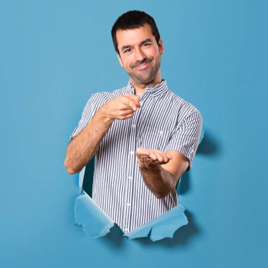 Yakışıklı adam bir şey bir kağıt delik tutan