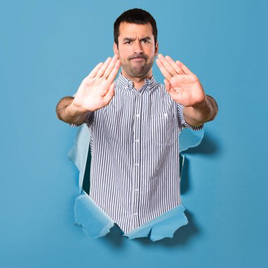 Yakışıklı adam dur işareti bir kağıt delik yapma