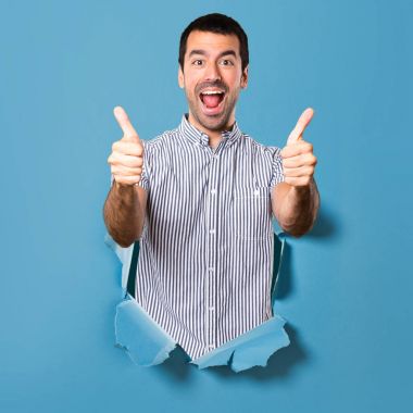 Yakışıklı adam ile bir kağıt delikten başparmak