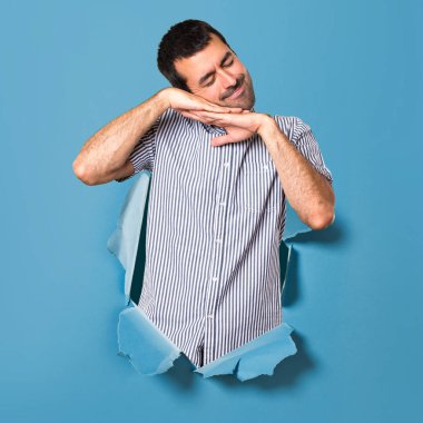 Yakışıklı adam yapma uyku jest bir kağıt delikten