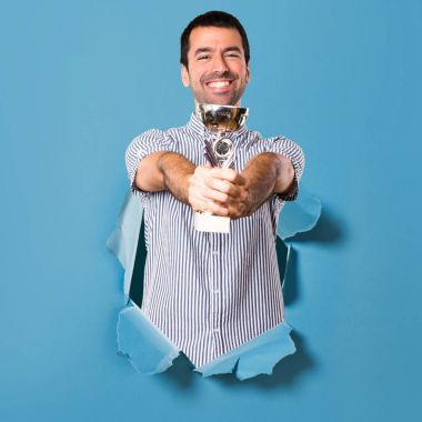 Bir kupa kağıt delik tutan mutlu yakışıklı adam