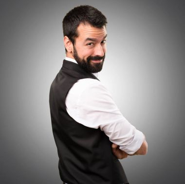 Kollarını ile cool adam gri arka plan üzerinde çarpı işareti