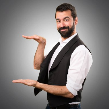 Cool adam bir şey gri arka plan üzerinde tutan