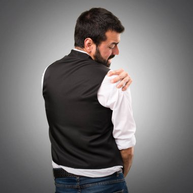 Omuz ağrısı gri arka plan üzerinde serin adam