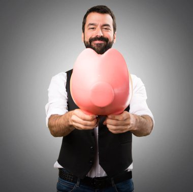 Cool adam gri arka plan üzerinde bir servet tutuyor