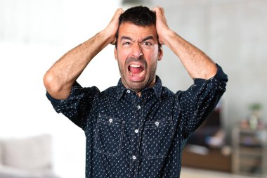 Evin içinde esmer adam sinirli