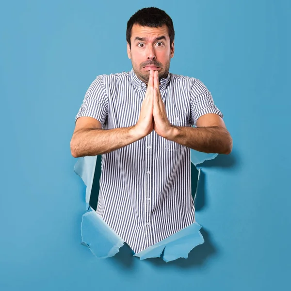 Hombre guapo suplicando a través de un agujero de papel —  Fotos de Stock