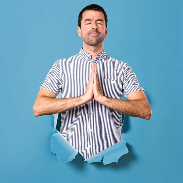 Bonito homem em posição zen através de um furo de papel — Fotografia de Stock