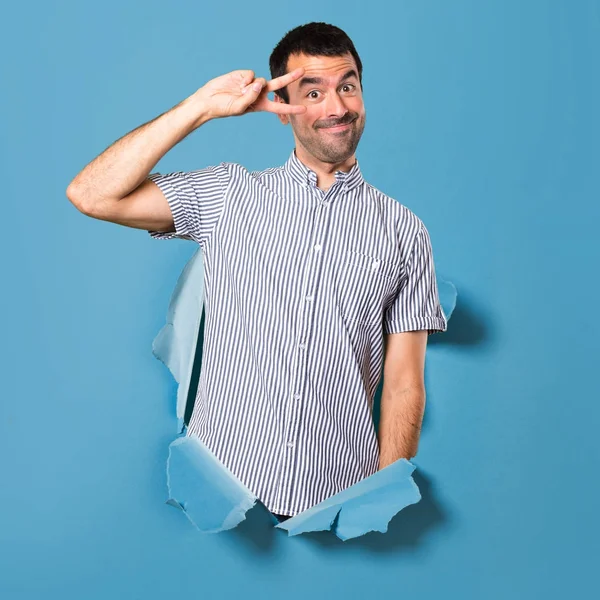 Hombre guapo bailando a través de un agujero de papel — Foto de Stock