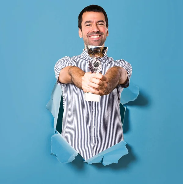 Bir kupa kağıt delik tutan mutlu yakışıklı adam