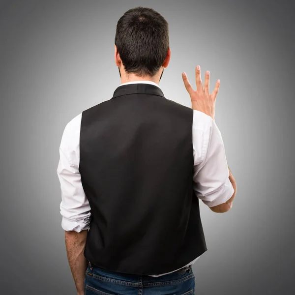 Cool man counting four on grey background — Stock Photo, Image