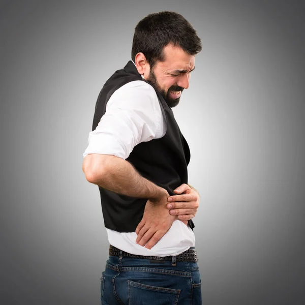 Прохолодний чоловік з болем у спині на сірому фоні — стокове фото