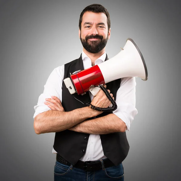Cool man holding a megaphone on grey background