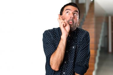 Esmer adam evin içinde geçiş parmaklarıyla