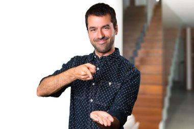 Esmer adam bir şey evin içinde tutan