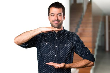 Esmer adam bir şey evin içinde tutan