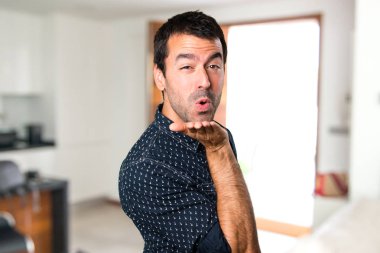 Esmer adam evin içinde bir öpücük gönderme