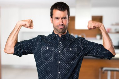 Esmer adam evin içinde güçlü bir jest yapma