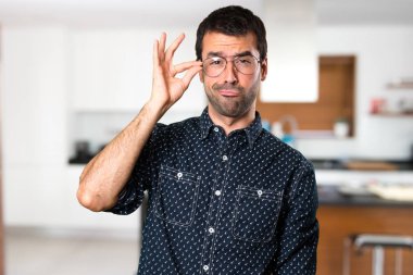 Evin içinde gözlüklü esmer adam