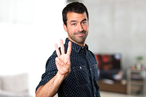 Brunette man counting three inside house — Stock Photo, Image