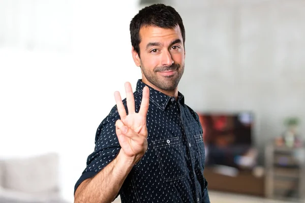 Brunette man tellen drie in huis — Stockfoto