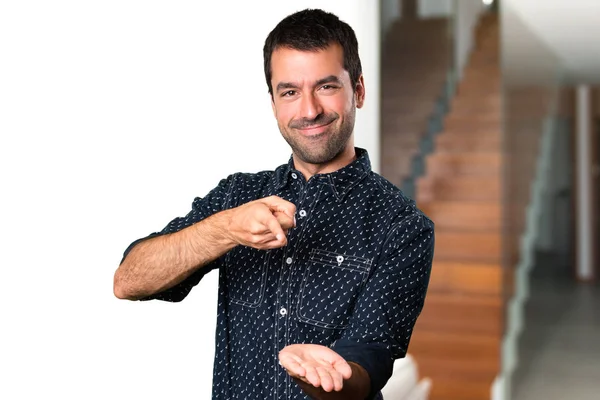 Esmer adam bir şey evin içinde tutan