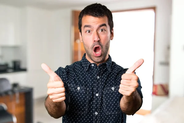 Brunette homme avec pouce à l'intérieur de la maison Images De Stock Libres De Droits