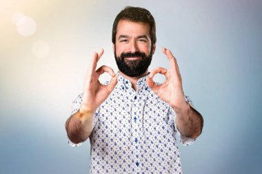 Ok işareti yapma sakallı yakışıklı esmer adam