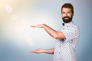 Bir şey tutan sakallı yakışıklı esmer adam