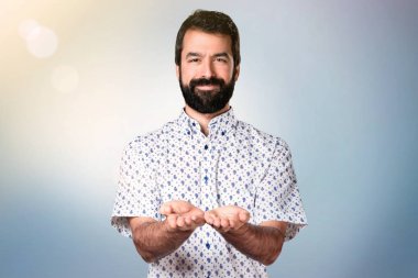 Bir şey tutan sakallı yakışıklı esmer adam