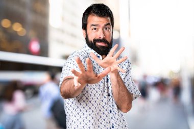 Dur işareti yapma sakallı yakışıklı esmer adam