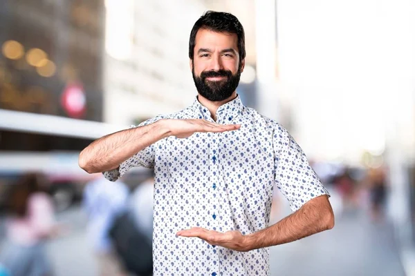 Knappe brunette man met baard iets te houden — Stockfoto