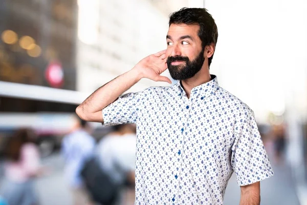 Красивый брюнетка мужчина с бородой слушать что-то — стоковое фото