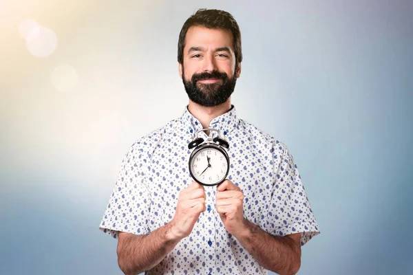 Handsome brunette man with beard holding vintage clock — Stock Photo, Image