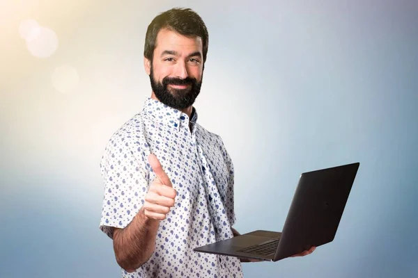 Hombre guapo morena con barba con portátil — Foto de Stock