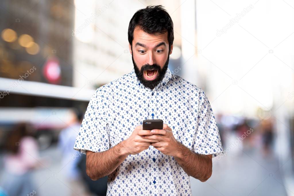 Handsome brunette man with beard talking to mobile