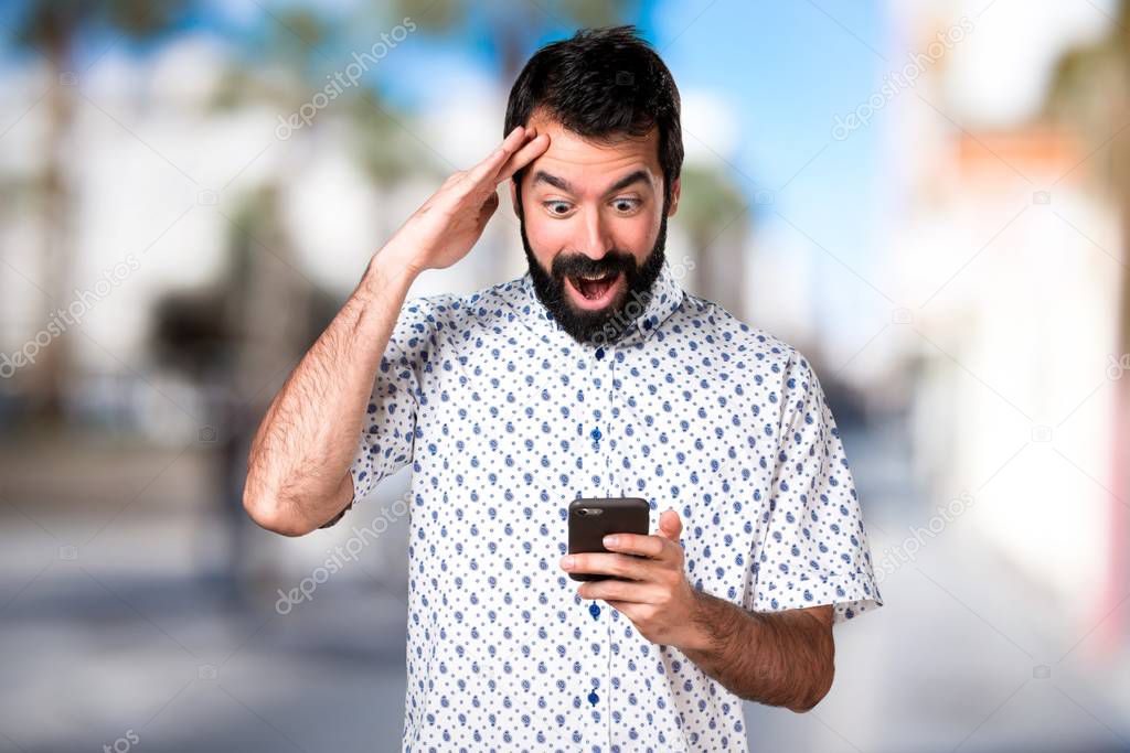 Handsome brunette man with beard talking to mobile