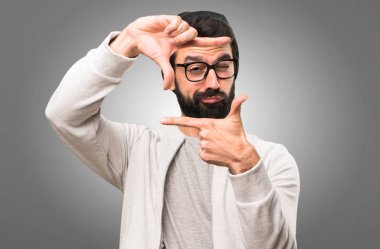 Onun parmaklarıyla gri arka plan üzerinde odaklanan hipster adam