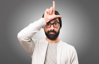 Hipster adam yapma kaybeden işareti gri arka plan üzerinde