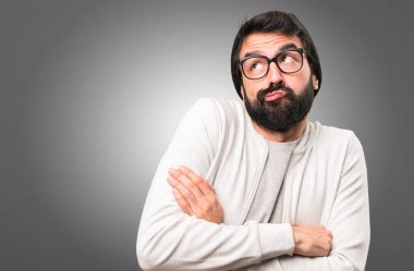 Hipster adam gri arka plan üzerinde önemsiz jest yapma