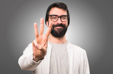 Hipster adam üç gri arka plan üzerinde sayma