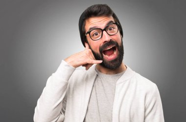 Hipster adam yapım telefon jest gri arka plan üzerinde