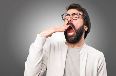 Hipster adam gri arka plan üzerinde esneme