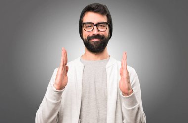 Bir şey gri arka plan üzerinde tutan hipster adam